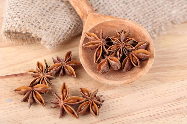 Star anise in wooden spoon, on wooden background — Stock Photo, Image