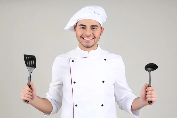 Profi szakács fehér egyenruhát és kalap, szürke háttér — Stock Fotó