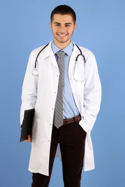 フォルダーは、青色の背景に立っている男性の医師 — ストック写真