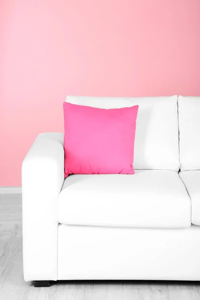 Hvit sofa på nært hold i rom med rosa bakgrunn – stockfoto