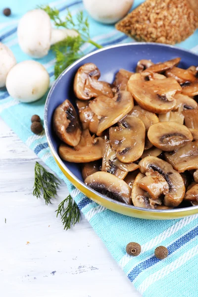 Heerlijke gebakken champignons in pan op tafel close-up — Stockfoto