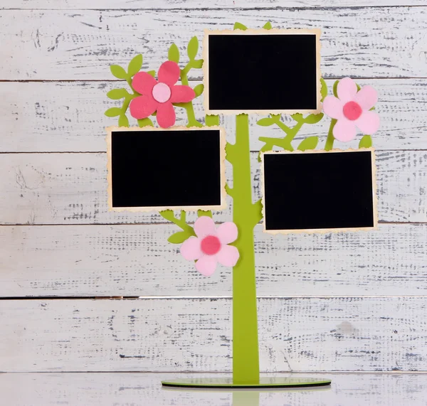 Supporto in forma di albero con schede fotografiche istantanee su sfondo di legno a colori — Foto Stock