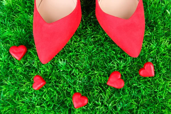 Vackra röda kvinnligt skor, på grönt gräs bakgrund — Stockfoto