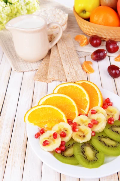 Свежие фрукты на тарелке на столе крупным планом — стоковое фото