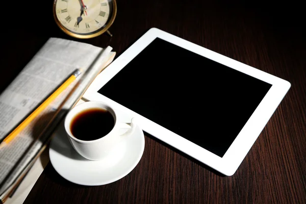 Tableta, periódico, taza de café y despertador en mesa de madera — Foto de Stock