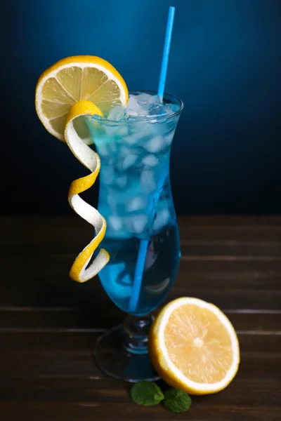 暗い青色の背景上のテーブルにカクテルのグラス — ストック写真