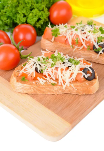 Deliciosa bruschetta con tomates en la tabla de cortar de cerca —  Fotos de Stock