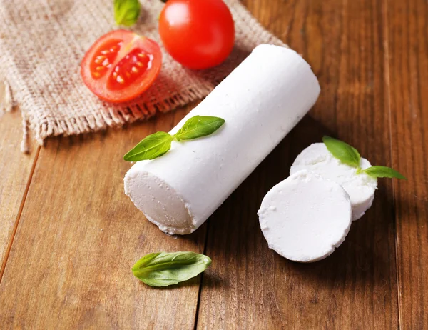 Queijo saboroso com manjericão e tomate, sobre mesa de madeira — Fotografia de Stock