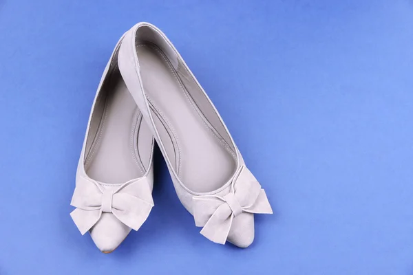 Hermosos zapatos femeninos grises, sobre fondo azul — Foto de Stock