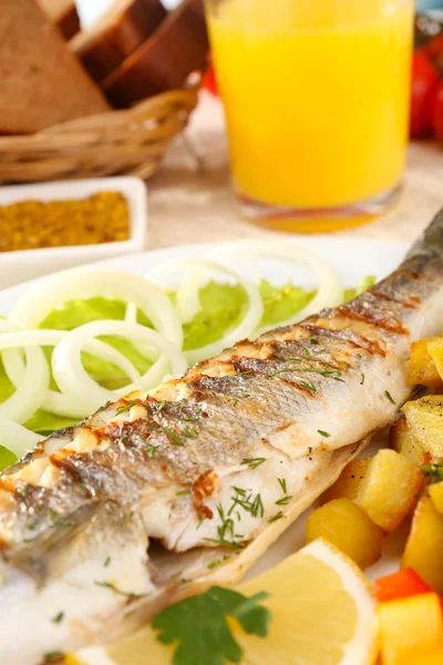 Delicioso pescado a la parrilla en el plato en primer plano de la mesa —  Fotos de Stock