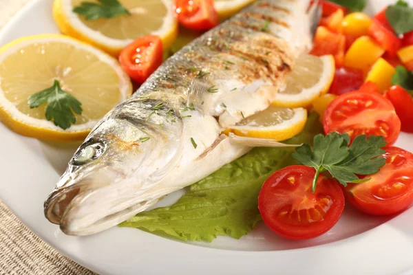 Delicioso peixe grelhado no prato na mesa close-up — Fotografia de Stock