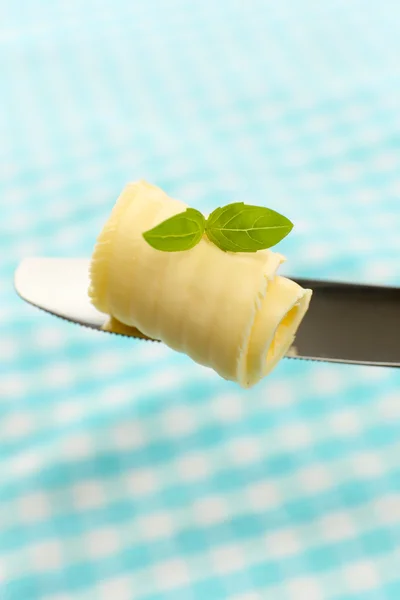 Rizo de mantequilla fresca con albahaca en el cuchillo sobre tela azul — Foto de Stock