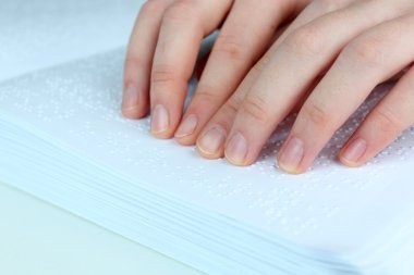 Blind woman read book written in Braille clipart