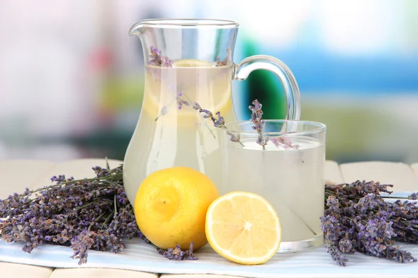 Limonada de lavanda en jarra de vidrio, en servilleta, sobre fondo brillante —  Fotos de Stock