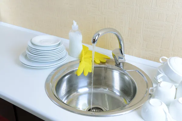 Посуда высыхает возле металлической раковины — стоковое фото