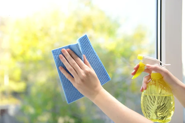 Mani con spray pulizia della finestra — Foto Stock