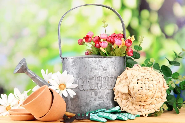 Herramientas de jardinería y flores sobre mesa de madera, al aire libre — Foto de Stock