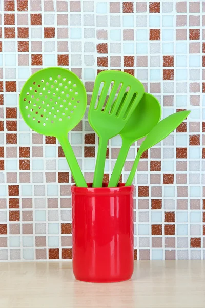 Kookgerei in de keuken op tafel op mozaïektegels achtergrond — Stockfoto