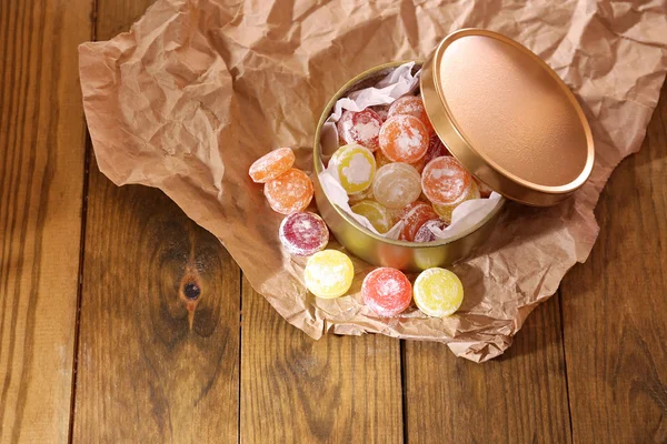 Sweet candies in metal can, on wooden background — Stock Photo, Image