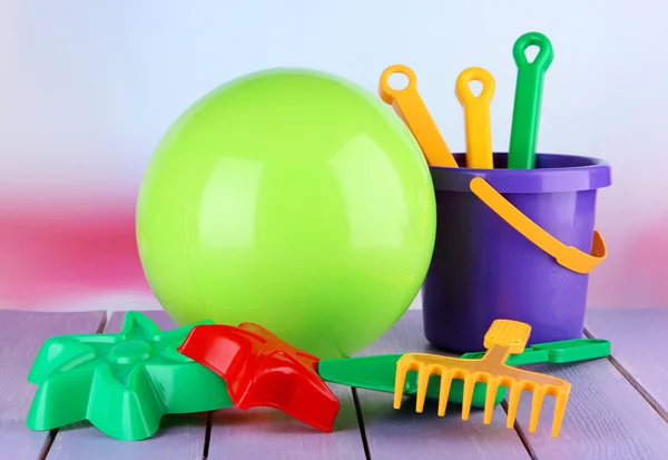 Brinquedos brilhantes de bola e sandbox na mesa em fundo brilhante — Fotografia de Stock