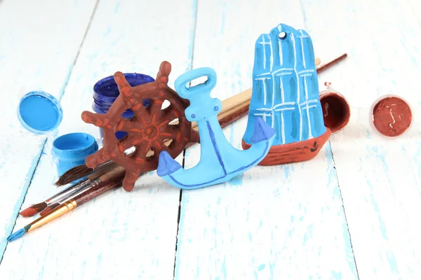 Juguetes de cerámica hechos a mano y pinturas de color en mesa de madera — Foto de Stock