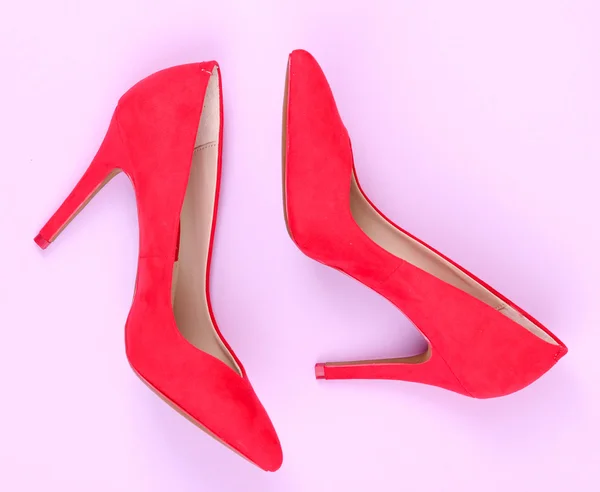 Krásné červené ženské boty, na fialovém pozadí — Stock fotografie