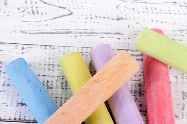 Krijtjes in verscheidenheid van kleuren, op houten achtergrond — Stockfoto