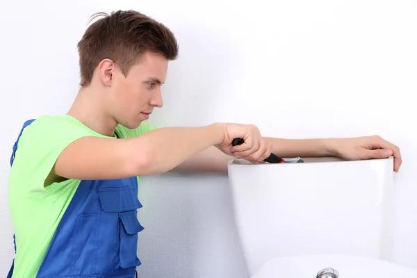 Plumber with toilet plunger on light background — Stock Photo, Image