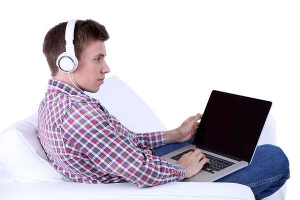Facet siedzi na kanapie i słuchając wobec muzyka na białym tle — Zdjęcie stockowe