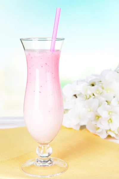 Batido de leche en la mesa sobre fondo azul claro —  Fotos de Stock