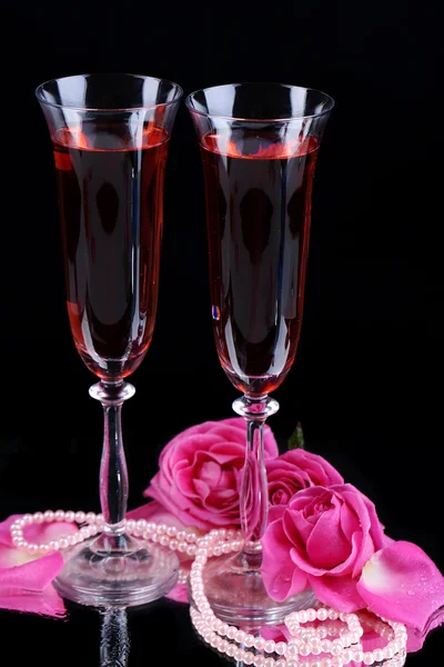 Composition with pink wine in glasses and roses isolated on black Royalty Free Stock Photos