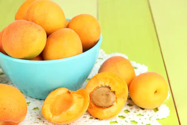 Frische natürliche Aprikose in Schale auf grünem Holztisch — Stockfoto