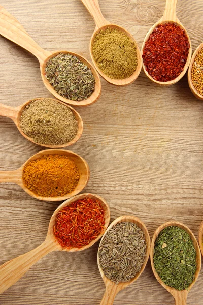 Assortimento di spezie in cucchiai di legno su fondo di legno — Foto Stock