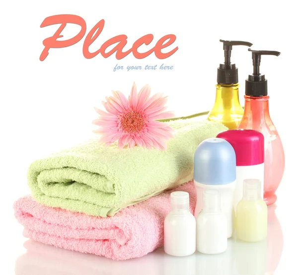 Garrafas de cosméticos com toalhas e flores isoladas em branco — Fotografia de Stock