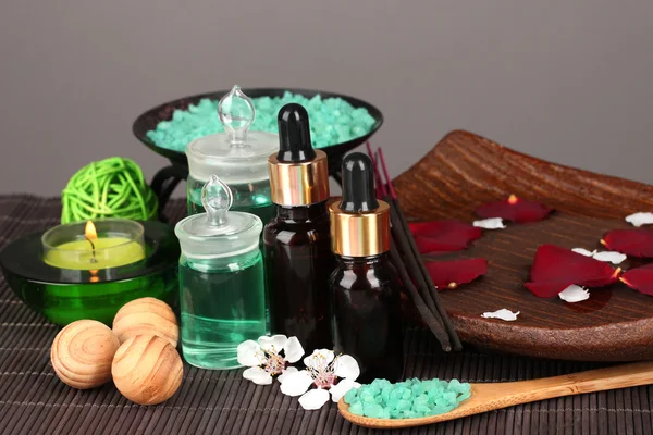 Spa kompozycja z olejkami aromatycznymi na stole na szarym tle — Zdjęcie stockowe