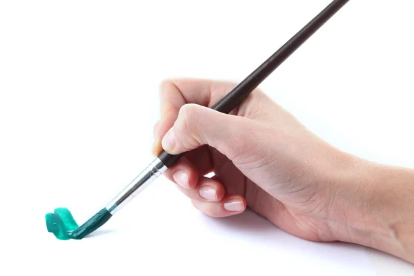 Hand holding brush with green paint isolated on white — Stock Photo, Image