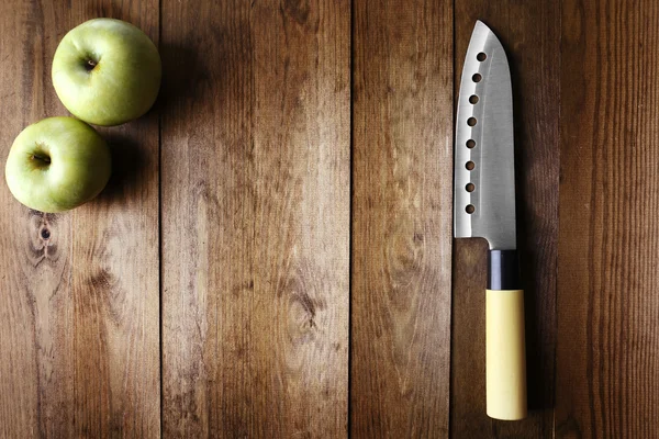 Kitchen knife and green apple, on wooden background — Stock Photo, Image