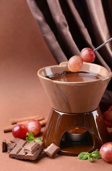 Шоколадное фондю с фруктами, на коричневом фоне — стоковое фото
