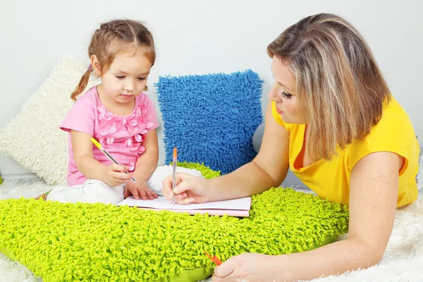 Liten flicka med mamma läsa bok i sängen — Stockfoto