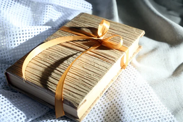 Book wrapped with color ribbon, on fabric background — Stock Photo, Image