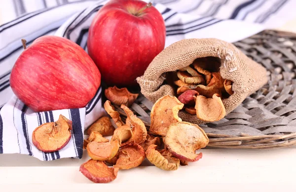 Dried apples and fresh apples, on napkin, on white wooden background — Stock Photo, Image