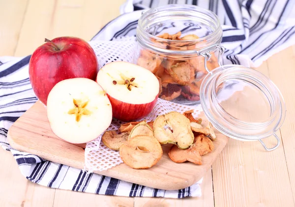 Manzanas secas en tarro de vidrio, sobre fondo de madera de color — Foto de Stock