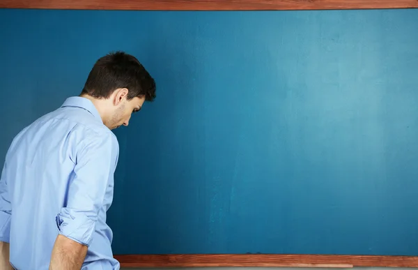 Νεαρός δάσκαλος κοντά chalkboard σε σχολική τάξη — Φωτογραφία Αρχείου