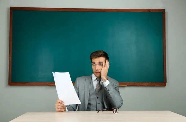 Jonge leraar zitten in school klas — Stockfoto