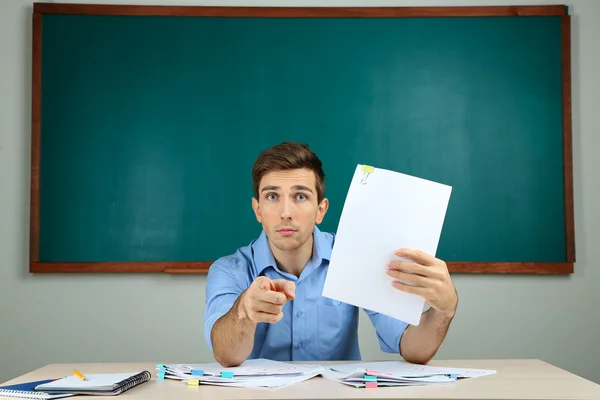 Junge Lehrer überprüfen Tests in der Schule Klassenzimmer — Stockfoto