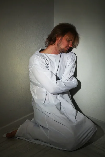 Mentally ill man in strait-jacket in room corner — Stock Photo, Image