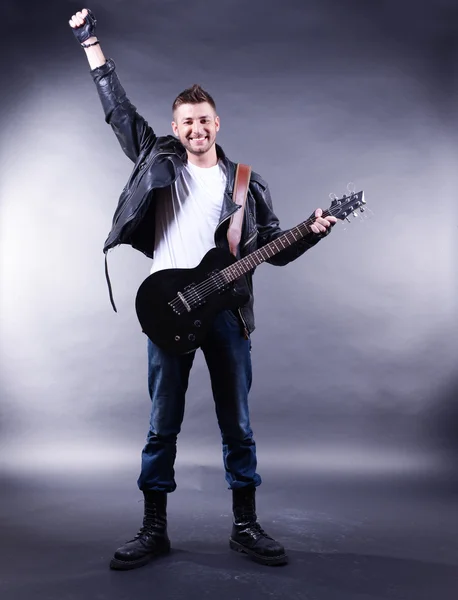 Young musician playing guitar on gray background — Stock Photo, Image