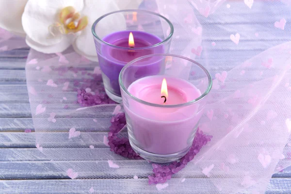 Krásné barevné svíčky a květy orchidejí, na barevné dřevěné pozadí — Stock fotografie