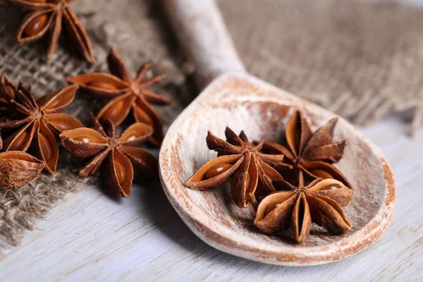 Star anise in wooden spoon, on wooden background — Stock Photo, Image