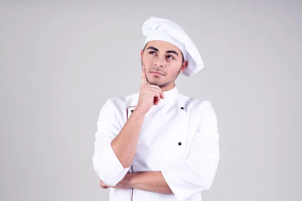 Professional chef in white uniform and hat, on gray background — Stock Photo, Image